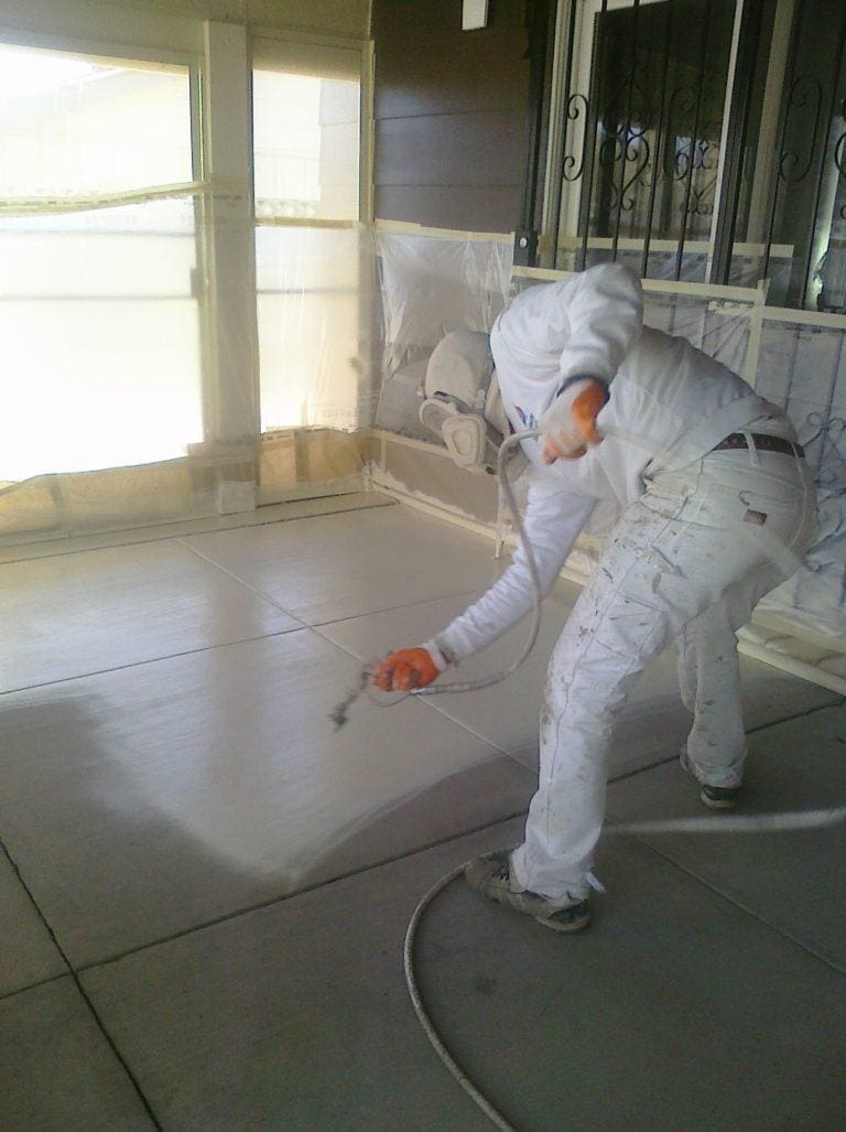 Man Spraying Paint on Floor